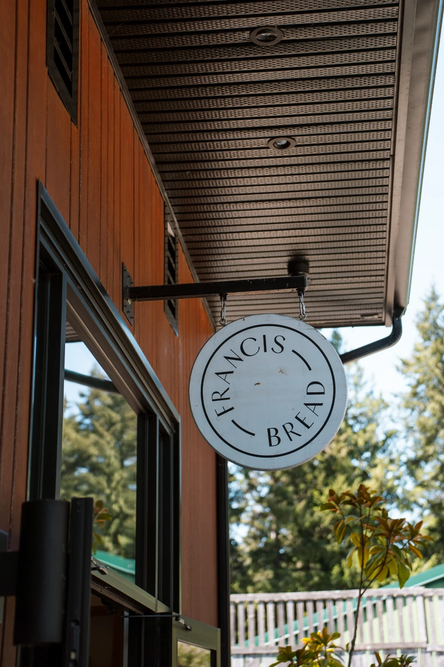 A sign hangs over the street reading 'Francis Bread'
