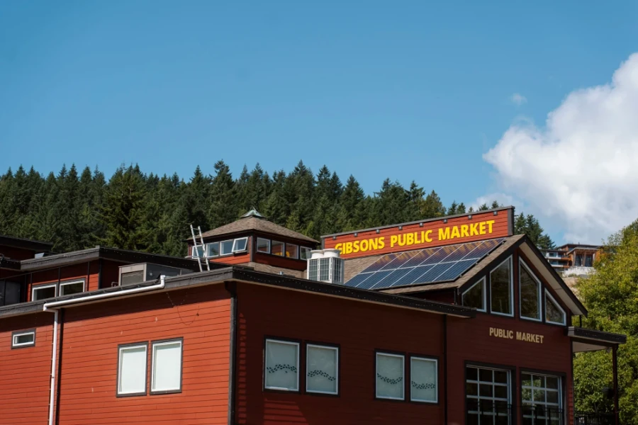 A large red building with yellow writing on the roof that reads Gibsons Public Market