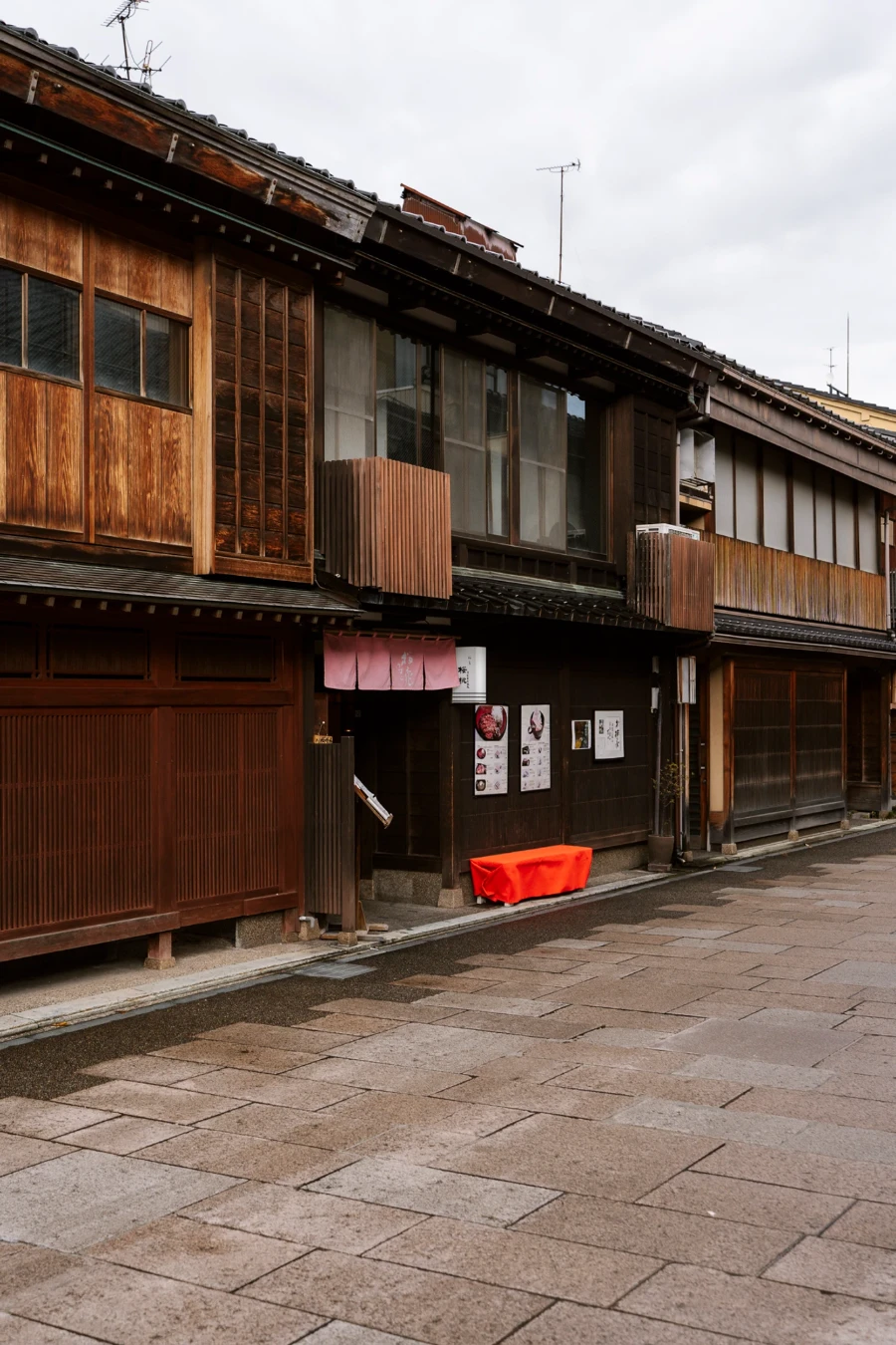 Empty stone street lined with traditional wooden Japanese store fronts