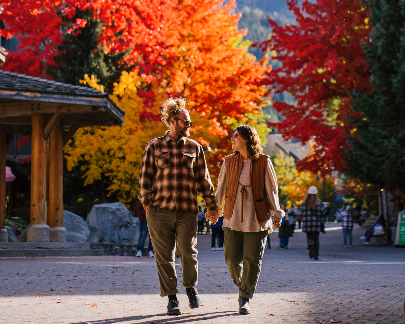 Blog authors Alia & Shawn walking hand in hand through Whistler village on a fall day.