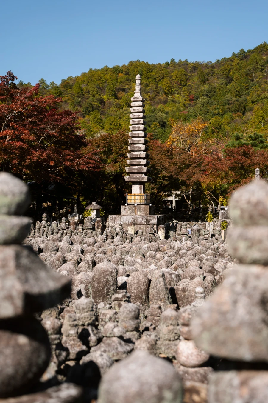 Hundreds of small stone statues surround one large statue at Adashino Nenbutsuji Temple