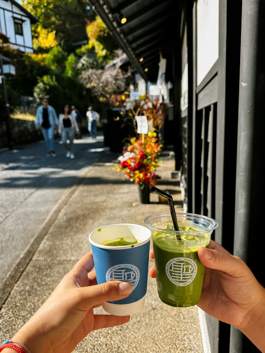 Two hands hold matcha drinks