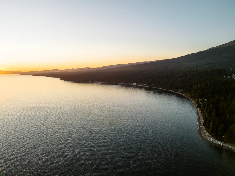 last rays of sunset lighting up the long stretch of white sand beach along Bonniebrooke Beach, BC