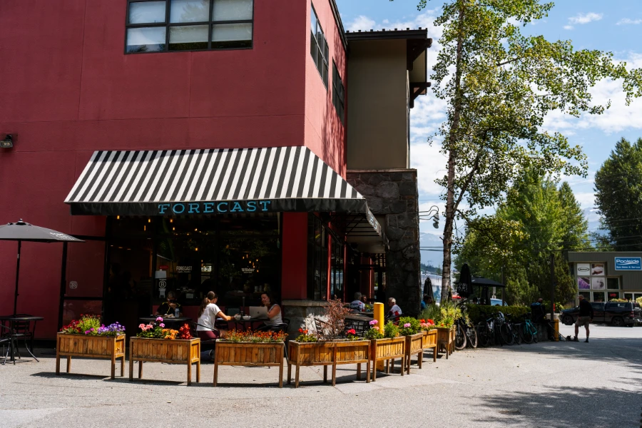 A curved row of wooden flower baskets demarcates the large outdoor patio space at Forecast Coffee