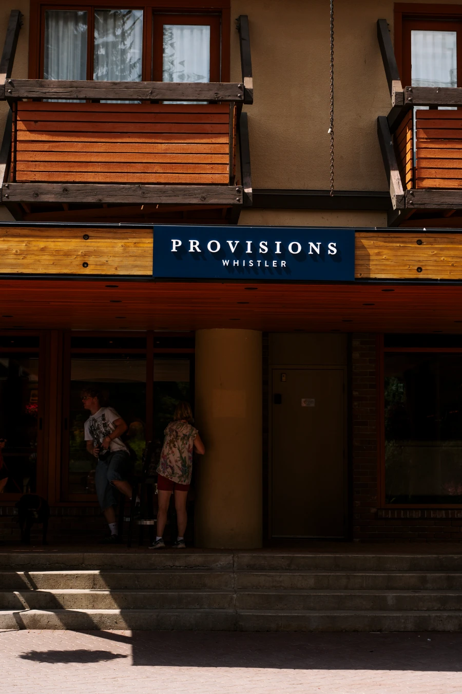 A large sign above the Whistler Village Stroll reads ‘Provisions Whistler’