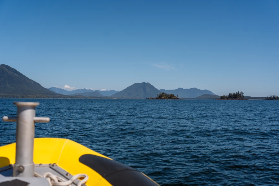 A large cone shaped mountain in the distance across a wide stretch of open ocean