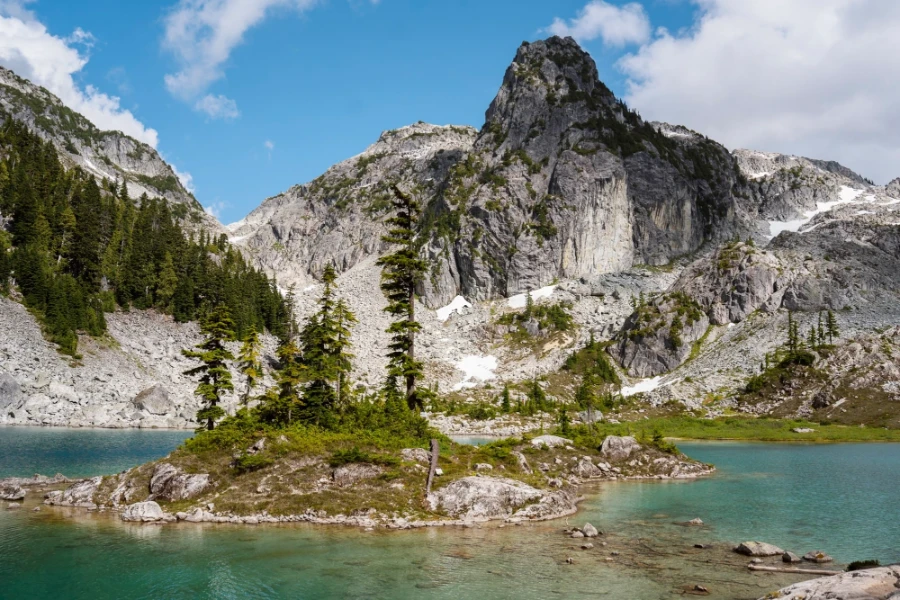 The shallow waters of Watersprite Lake surround a small rocky island that has several sparse trees growing on it.