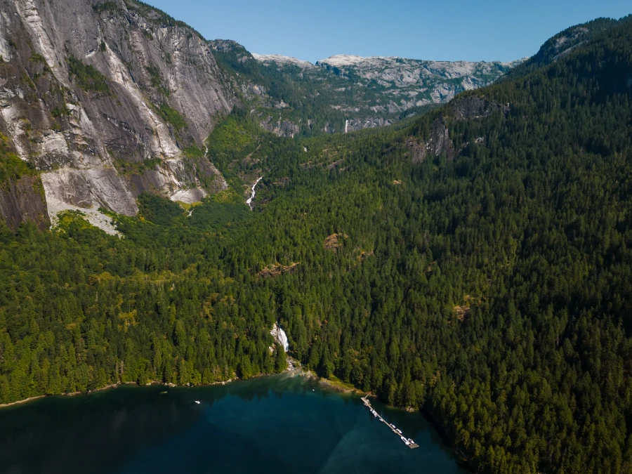 Chatterbox fall surrounded by trees and cliffs pouring a steady stream into Princess Louisa Inlet