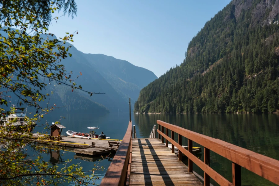 Wooden dock at Princess Louisa Inlet leads around to the left towards a docked zodiac boat