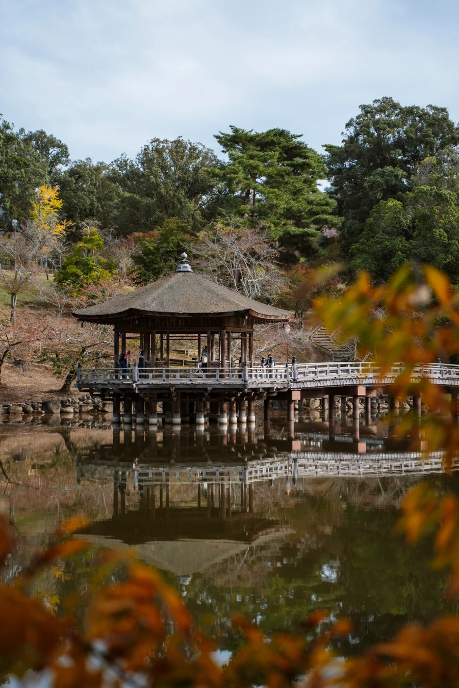 Wooden pagoda on stilts above the water Nara Park, Japan being reflected in the calm water below