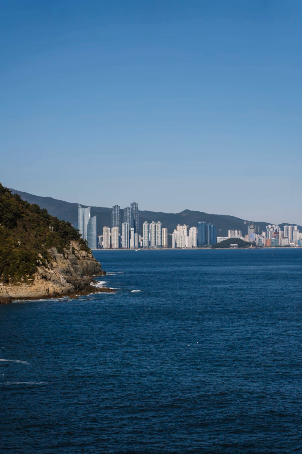 Skyline of Busan across a large stretch of ocean
