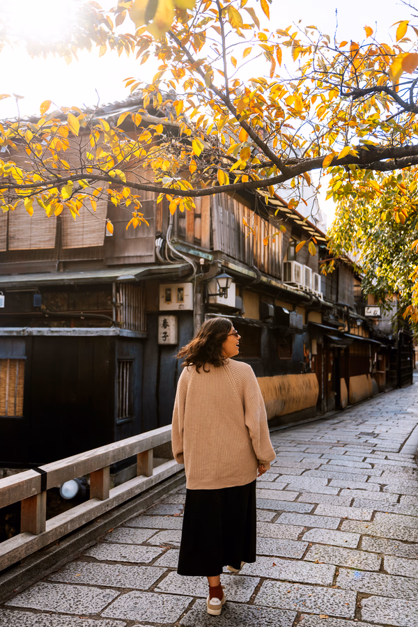 A woman walking across a stone bridge in the Gion neighbourhood in Kyoto, Japan