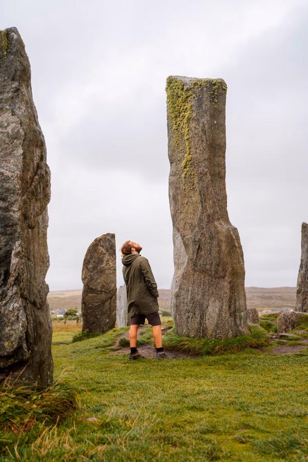 Man looks up inquisitively at the Calanais Standing Stones