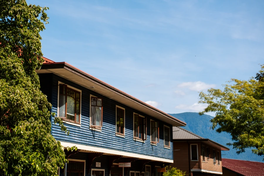 Line of windows opening out of a blue wooden facade of an old hotel on Bowen Island, BC