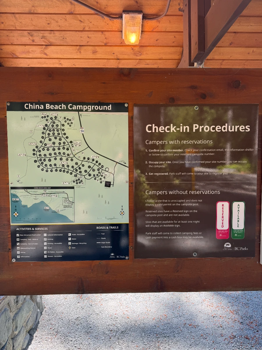 A wooden billboard shows a map of China Beach Campground as well as a list of check-in procedures
