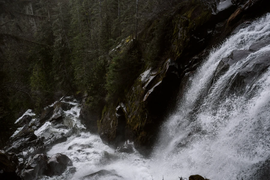 Powerful stream of water pours down a cliff and makes a nearly 90 degree turn