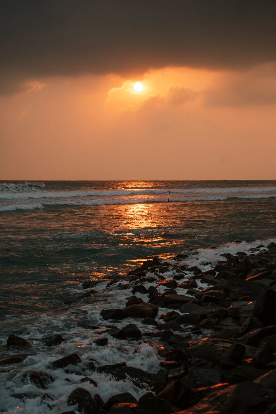The setting sun refleted in the rough waters off the coast of Ahangama, Sri Lanka