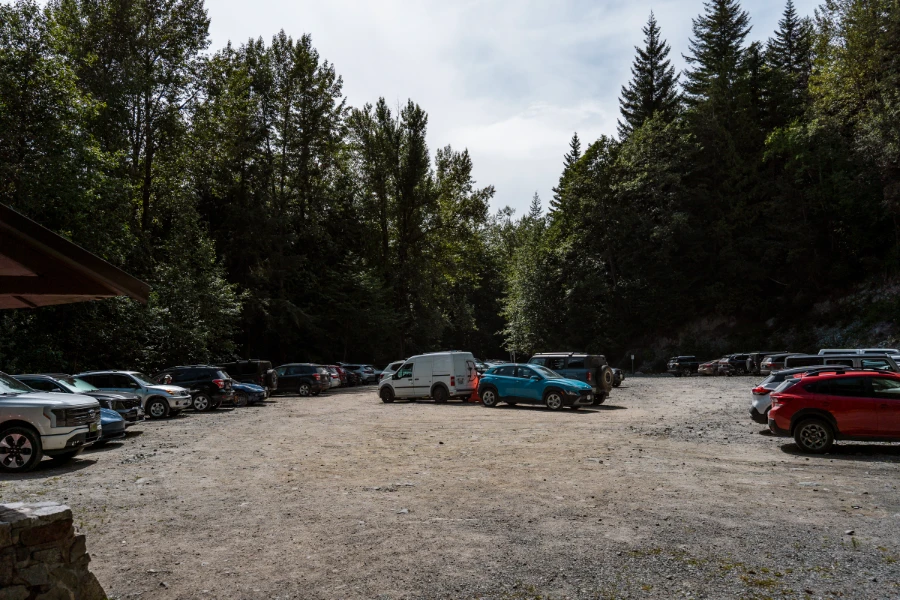 A large flat dirt parking lot filled with rows of cars at the trailhead for the Elfin Lakes Hike.