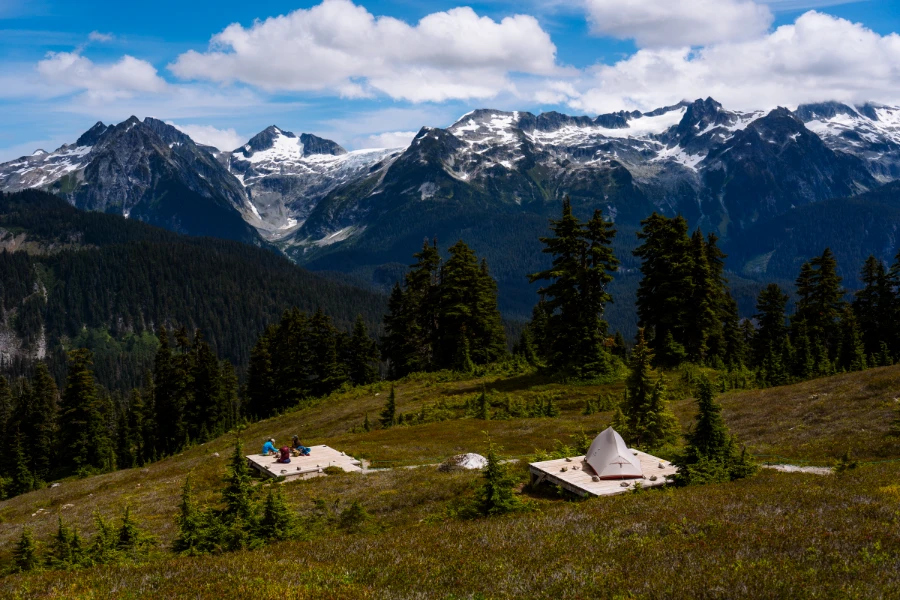 Wooden tent pads on the side of a mountain looking out to peaks and glaciers in Garibaldi Provincial Park.