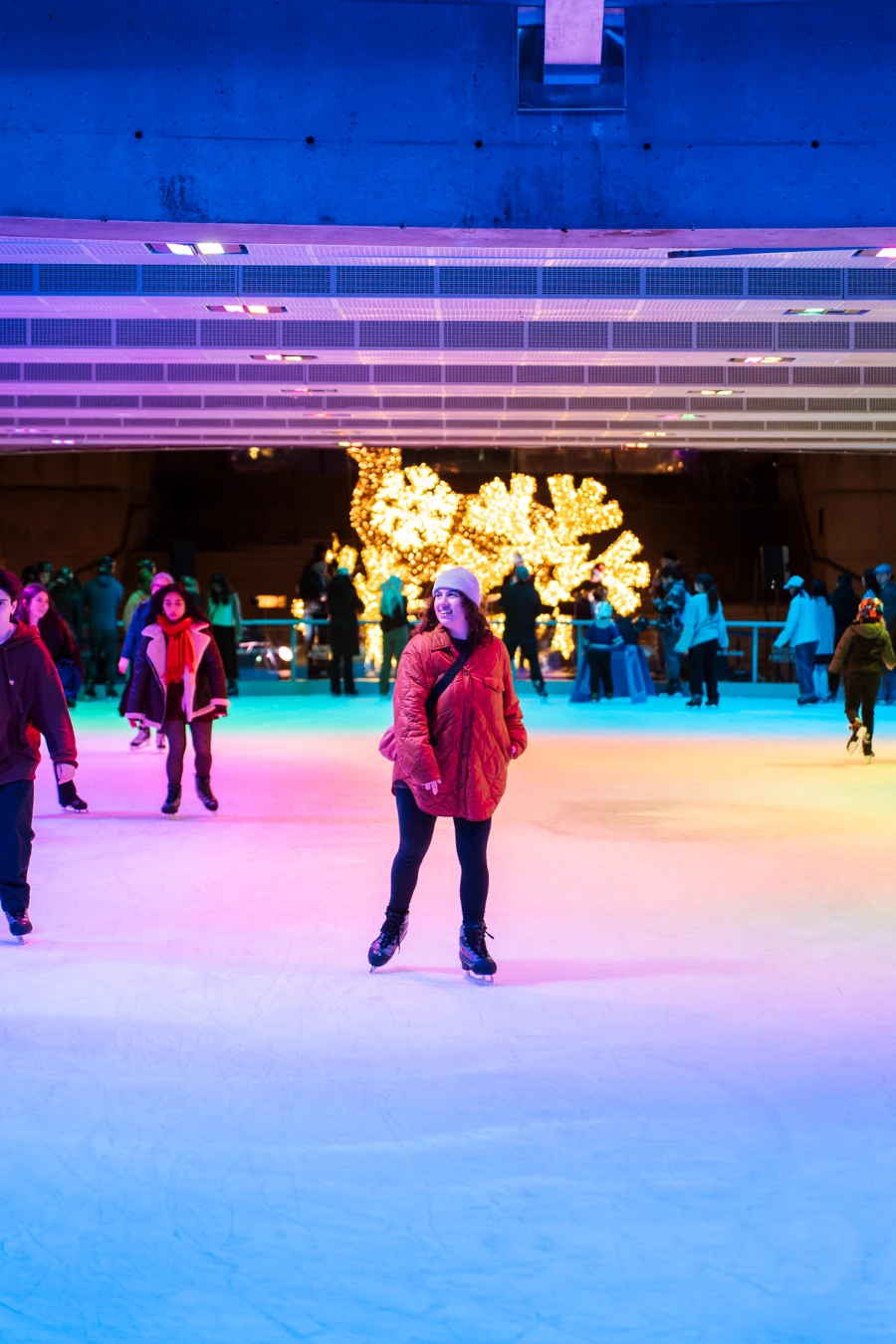 A woman skates through a busy ice rink downtown Vancouver