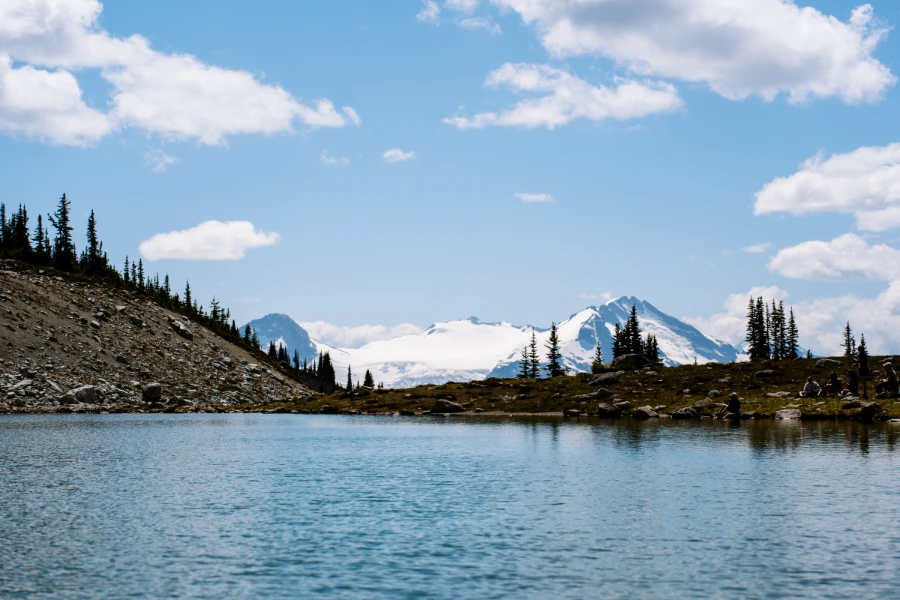The deep blue water of Blackcomb Lake with a massive glacier visible in the distance