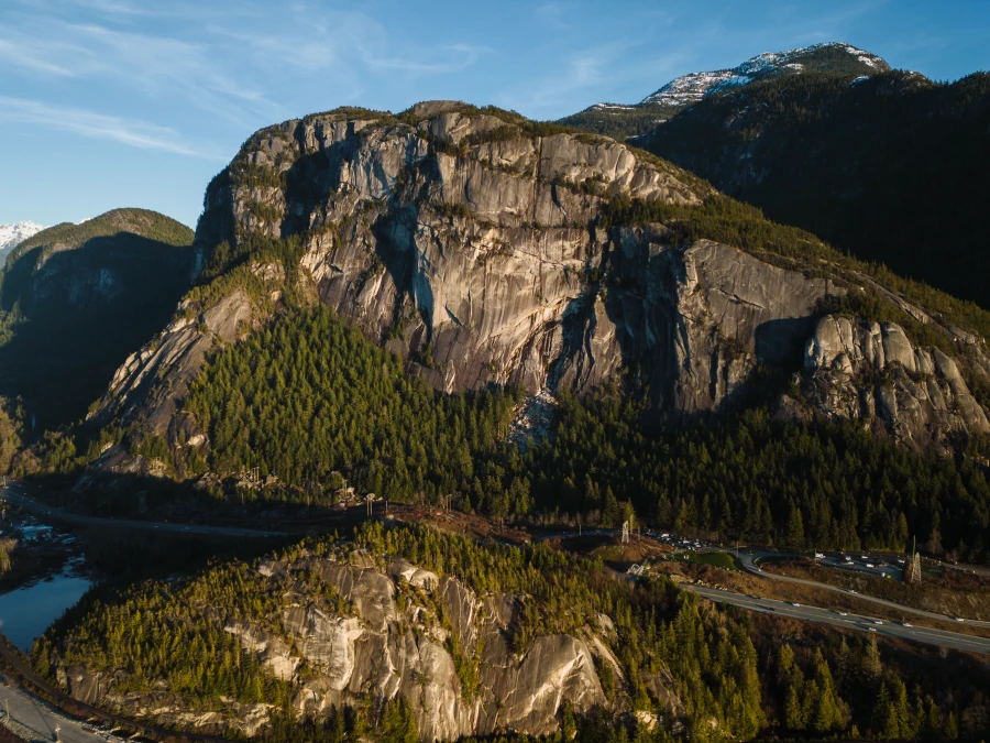 The bare granite cliff faces of the Stawamus Chief with the Sea to Sky Highway running beneath it.