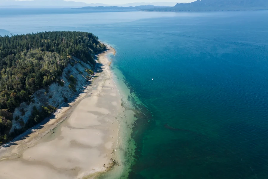Large stretch of white sand on Vaucroft Beach bordered on one side by limestone cliffs and the other by the sea