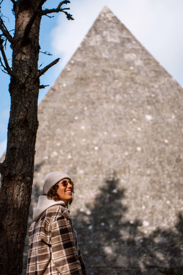 Portrait of a woman standing in front of a large stone pyramid