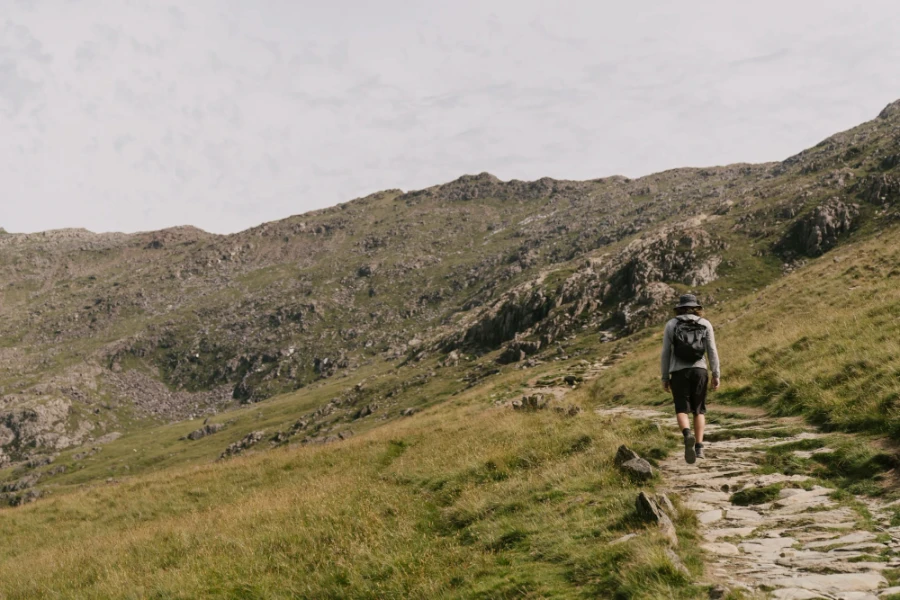 A man walking along a stone path on his way up Mount Snowdon
