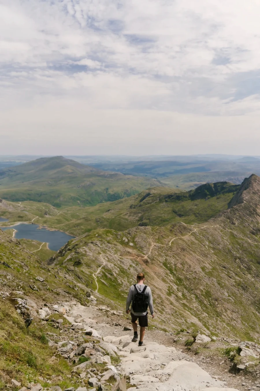 A man walking down stone stairs near the peak of Mount Snowdon