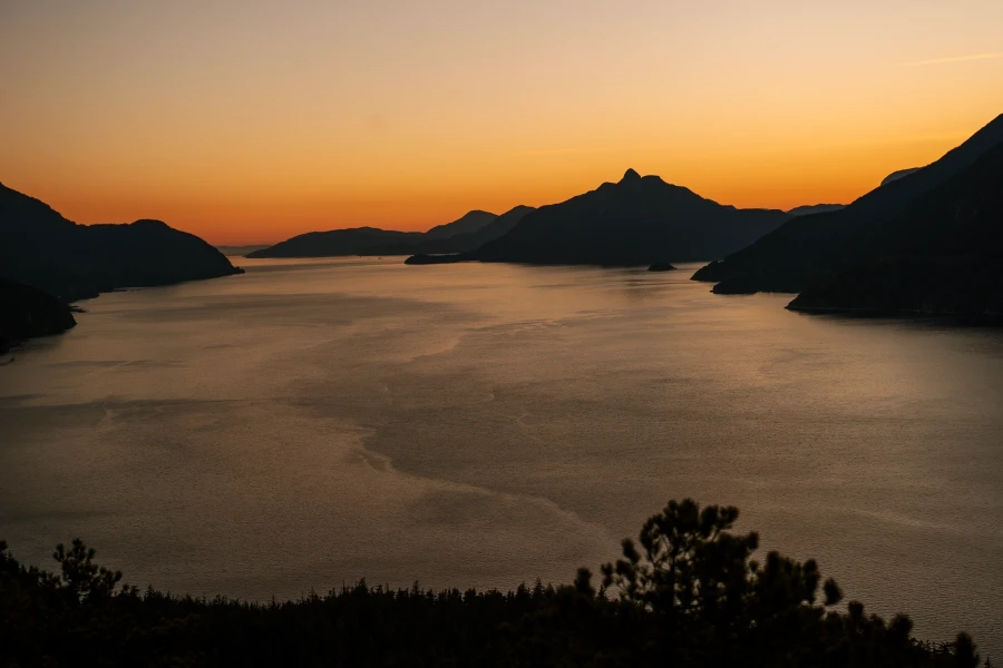 Mountains across the Howe Sound glow orange in the late sunset
