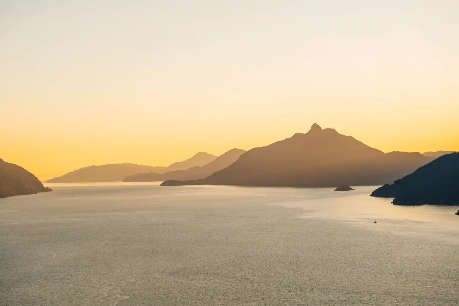 Mountains across the Howe Sound glow yellow in the sunset