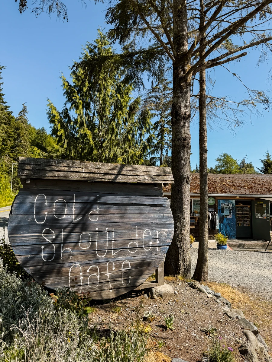 A wooden sign with handwritten letters reads ‘Cold Shoulder Coffee.’