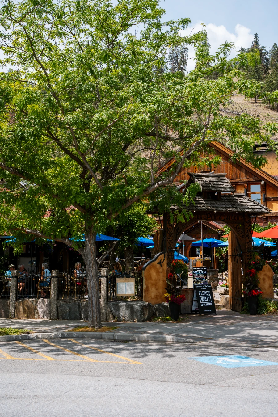 An enclosed patio space with several blue umbrellas sticking up above the walls in Peachland