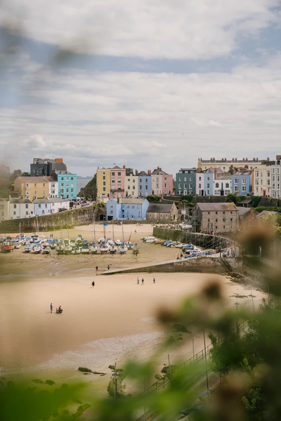 A large sandy beach backed by a row of colorful houses