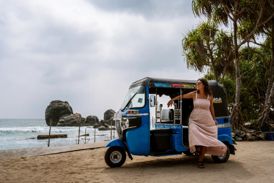 A woman stand outside a tuktuk on the South coast of Sri Lanka