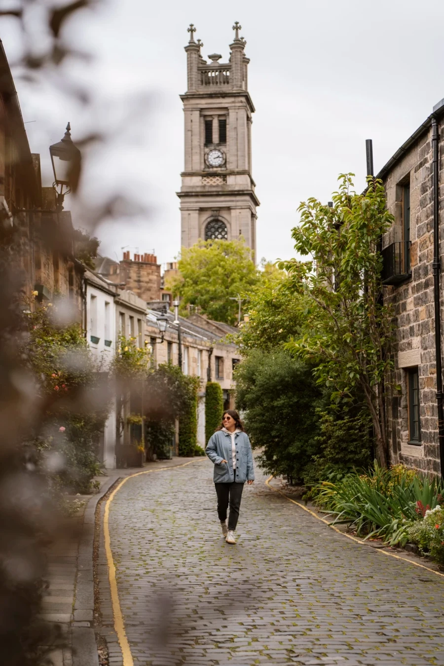A woman walks along a cobblestone path through Edinburgh's Stockbridge neighbourhood