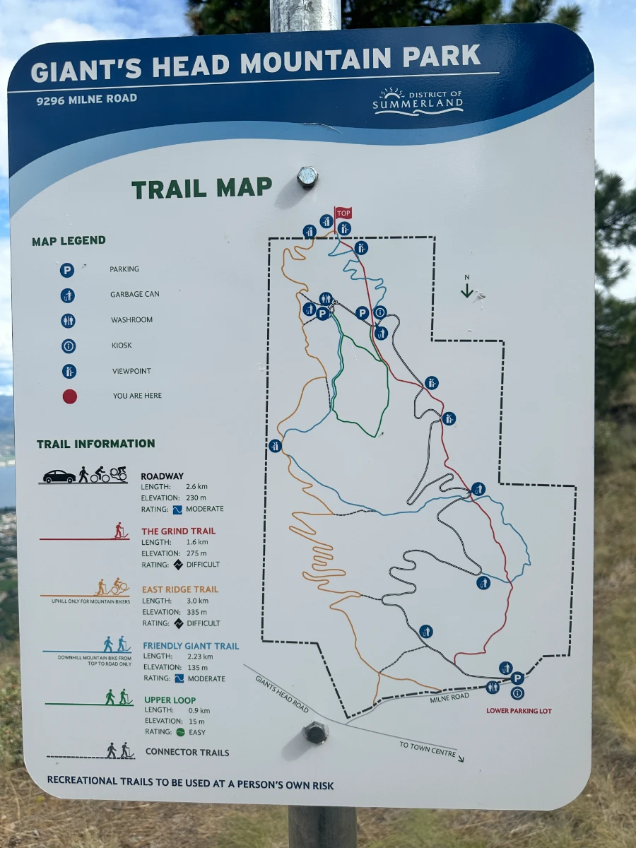 A trail map on a metal sign attached to a metal pole shows the various routes and their relative difficulties in Giant’s Head Mountain Park