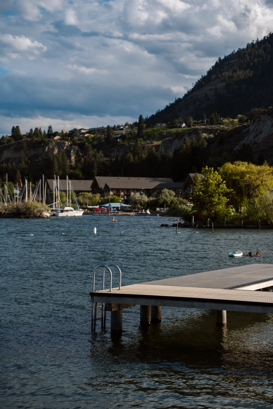 A metal ladder climbs out from the waters of Okanagan Lake and connects with an L-shaped plastic dock that is suspended above the water at Gordon Beggs Rotary Beach
