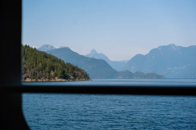 Rocky islands covered in trees framed through a BC ferry window