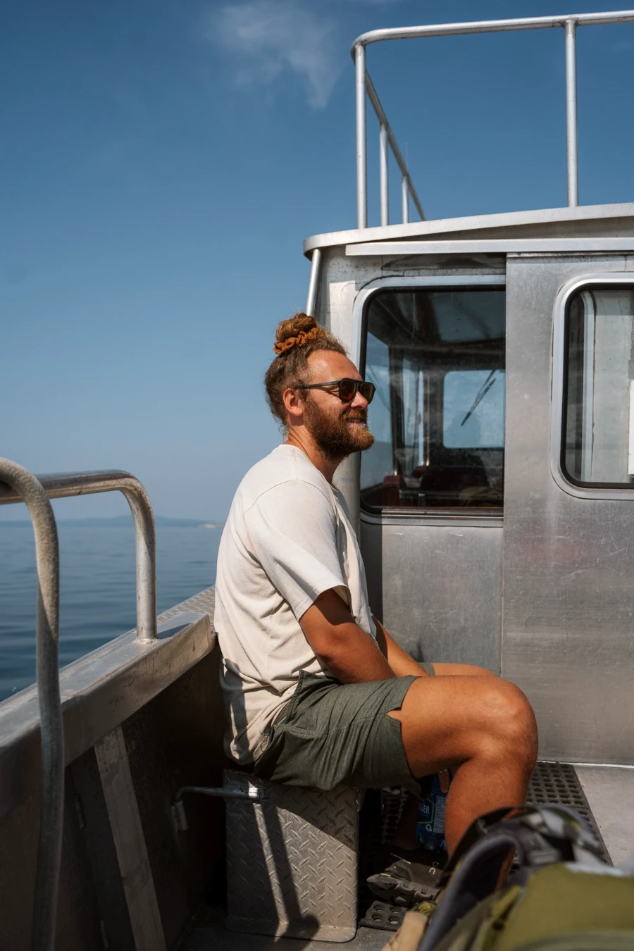 man sitting on the outdoor seat of a water taxi bound for Savary Island