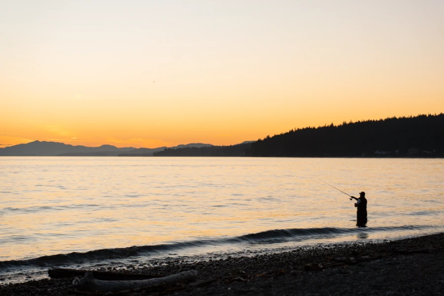 Fisherman casting a line at sunset near Gibsons on the Sunshine Coast, BC