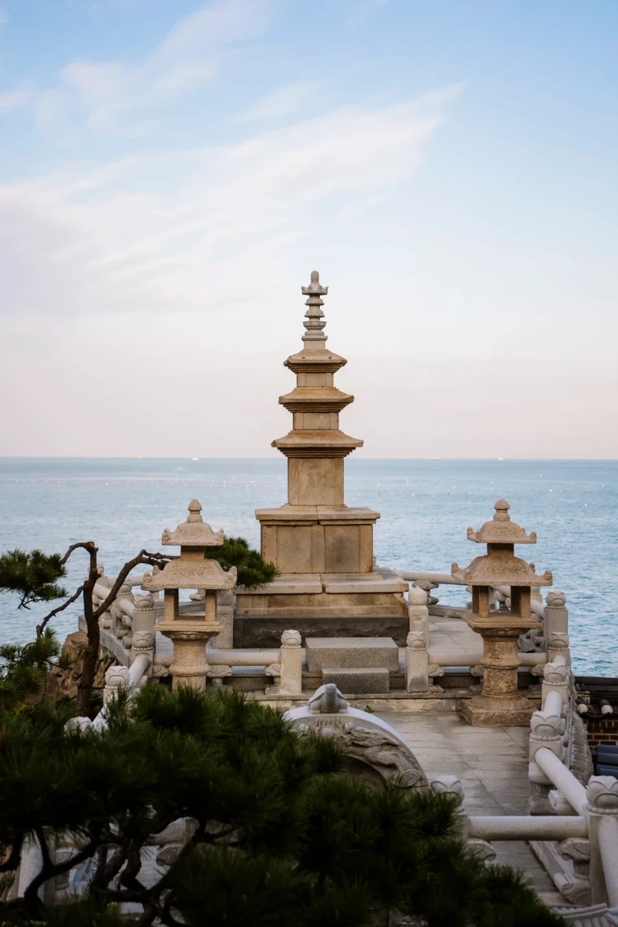 Three stone pagodas sit on the edge of a sea-side cliff at Haedong Yonggungsa Temple