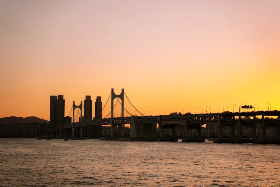 The sky glowing orange as the sun sets over The Gwangan Bridge in Busan, South Korea