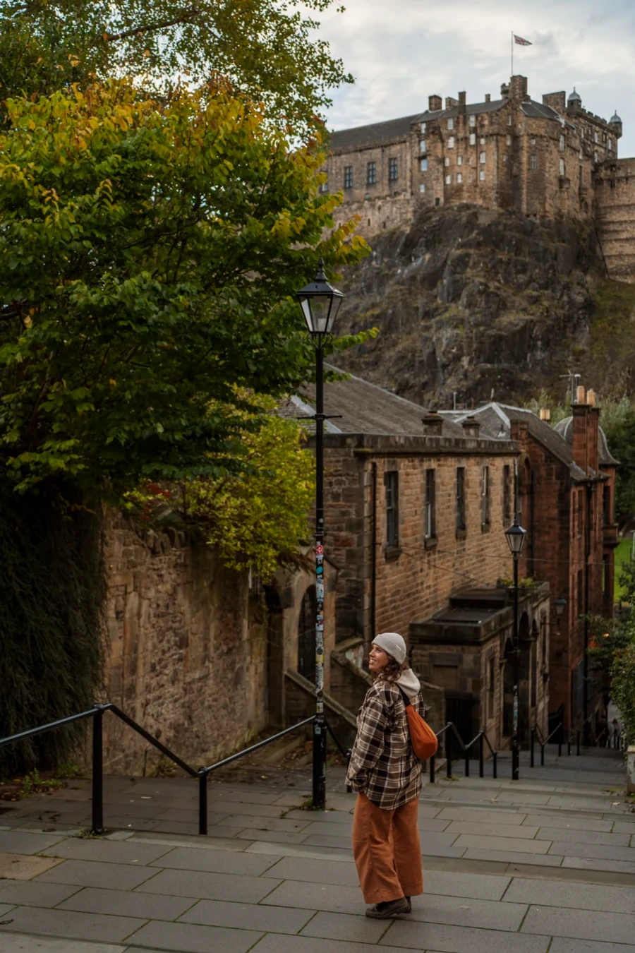 Woman on the steps near the Vennel Viewpoint looking up at Edinburgh Castle