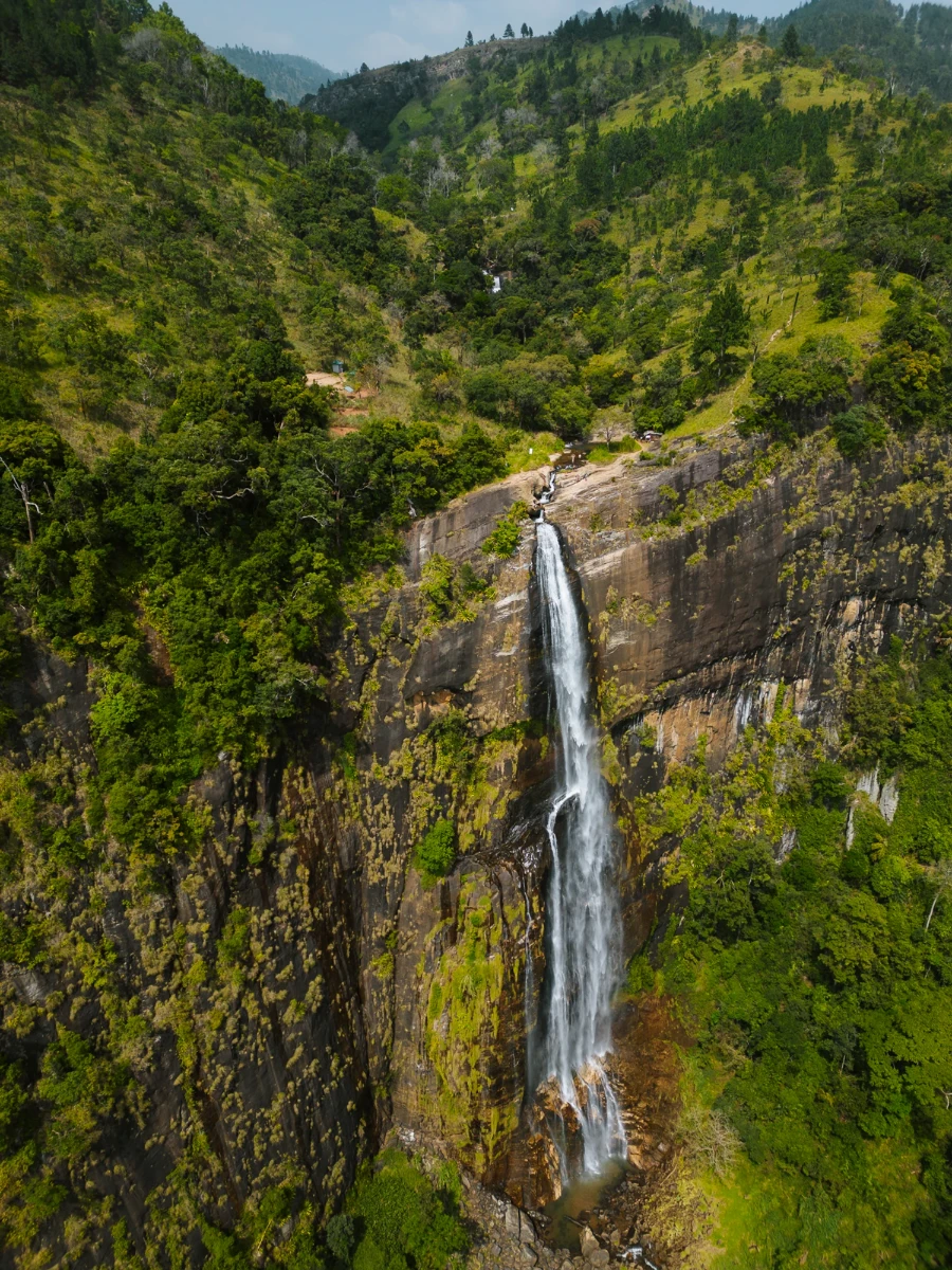Diyaluma Falls in Sri Lanka dropping off a massive cliff that is lined by thick jungle on either side