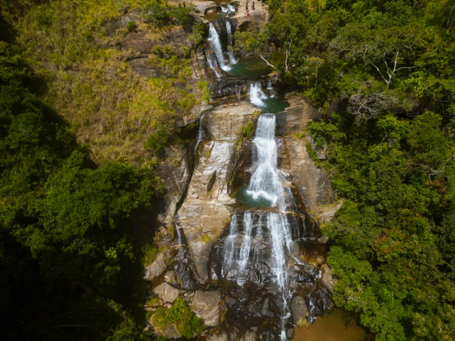 Several levels of waterfalls cascade into rocky pools near upper Diyaluma Falls