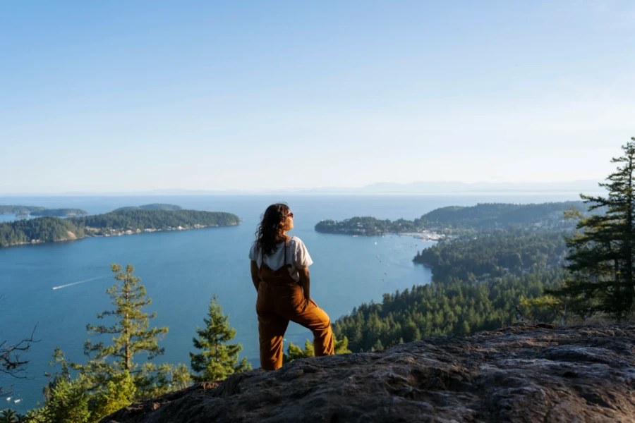 woman stands atop Soames Hill looking out to Keates island in the distance
