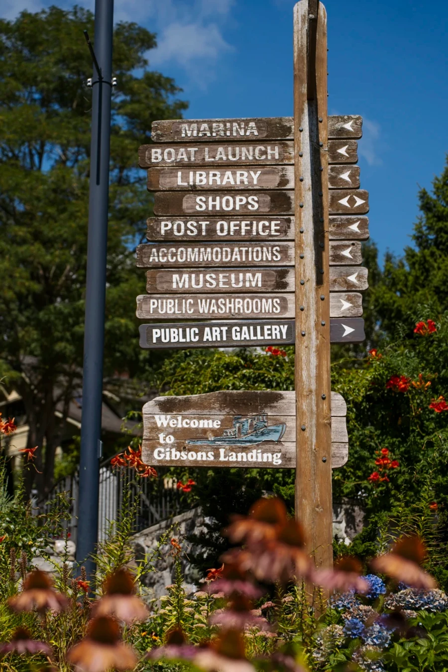 signpost near Gibsons' waterfront that reads welcome to Gibsons Landing and points to several points of interest