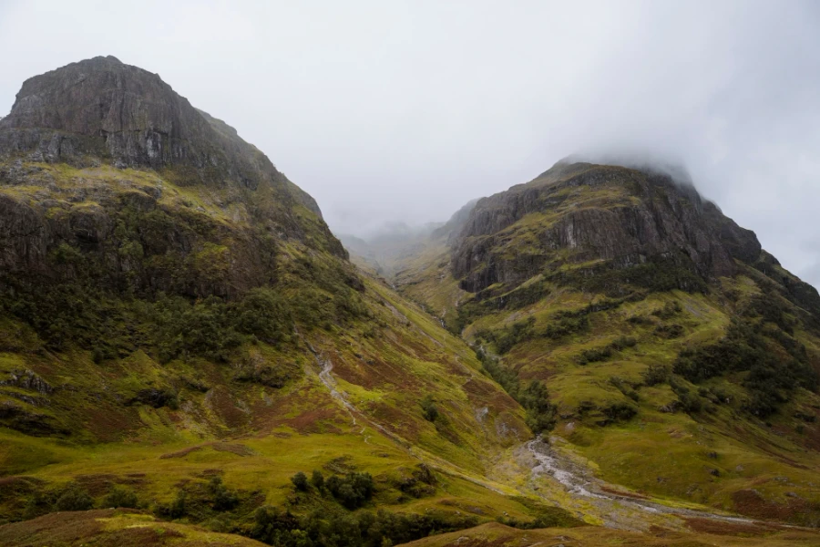 Two massive and misty mountains known as The Three Sisters of Glencoe in Glencoe, Scotland.
